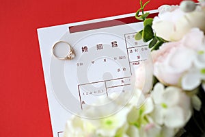 Japanese marriage registration blank document and wedding proposition ring and flowers on table