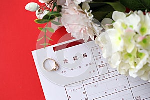 Japanese marriage registration blank document and wedding proposition ring and flowers on table