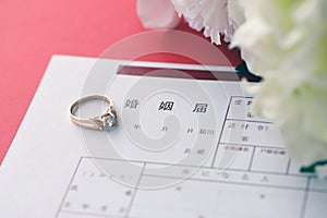 Japanese marriage registration blank document and wedding proposition ring and flowers on table
