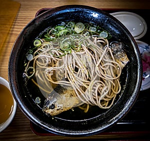 Japanese meal, hot soba noodles with herring fish.