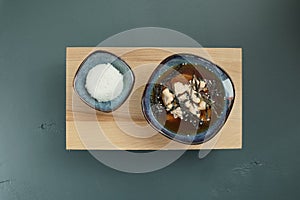 Japanese miso soup and rice on a red bowl and spoon on the table.