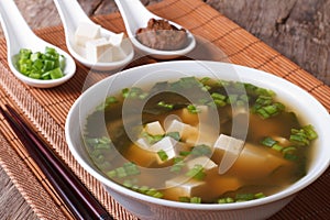 Japanese miso soup in a white bowl and ingredients close-up. Horizontal photo