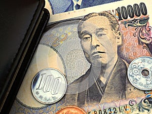 Japanese money, notes and coins are near the diary. 10,000 yen banknote close-up. News about the economy, the Bank of Japan and