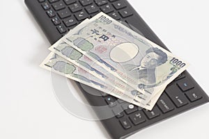 Japanese money one thousand yen on computer keyboard