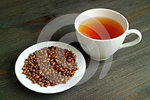 Japanese Mugicha or Barley Tea with a Plate of Roasted Barley on Wooden Table