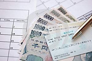 Japanese my number card specimen and notification card on calendar background with money