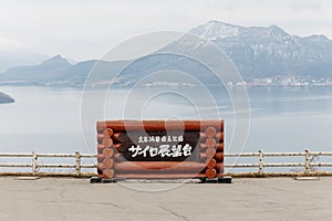 Japanese name of Lake Toya with snow mountain and city in the background in winter in Hokkaido, Japan