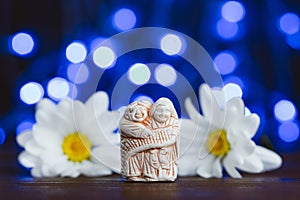 Japanese netsuke Kanzan and Jittoku in daisy flowers on blue background. Symbols of harmony