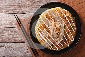 Japanese okonomiyaki on a wooden table. Horizontal top view