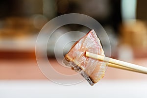 Japanese Omakase meal: closed up Aged Akami Tuna Lean Tuna pinching with chopsticks. Japanese luxury meal