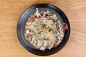 Japanese omelette Okonomiyaki, with eggs, Savoy cabbage, mayonnaise, carrot, zucchini, ginger, dried seaweed and Katsuobushi,