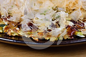 Japanese omelette Okonomiyaki, with eggs, Savoy cabbage, mayonnaise, carrot, zucchini, ginger, dried seaweed and Katsuobushi,