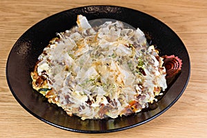 Japanese omelette Okonomiyaki, with eggs, Savoy cabbage, mayonnaise, carrot, zucchini, ginger, dried seaweed and Katsuobushi,