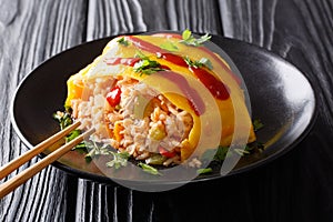 Japanese omurice omelette with rice, chicken and vegetables close-up. horizontal