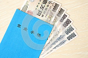 Japanese pension insurance book on table with yen money bills. Blue book for japan pensioners