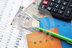 Japanese pension insurance booklets on table with yen money bills and calculator on table