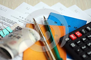 Japanese pension insurance booklets on table with yen money bills, pen and calculator on table