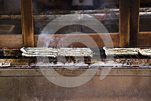 Japanese people cooking kabayaki or cooked grilled and roasted eel fish with sweet sauce in local restaurant in Narita at Japan