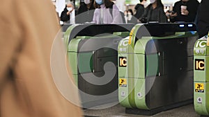 Japanese people, crowd Asian travelers walk pass automatic ticket turnstile gate at Japan subway station entrance