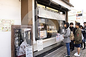 Japanese people and foreign traveler stand waiting line up for buy Dango or Japanese dumpling and sweet made from mochiko