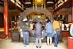 Japanese people and foreigner travelers praying buddha god of Marishiten Tokudaiji Temple in Ameyoko at Ueno in Tokyo, Japan