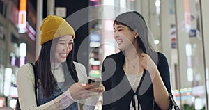 Japanese people, phone and city for night travel, walking and talk of social media, news or information. Women or young