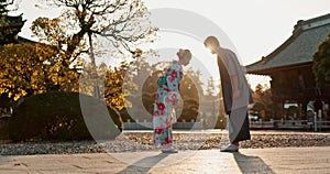 Japanese people at temple, bow and traditional clothes with hello, nature and sunshine with respect and culture. Couple
