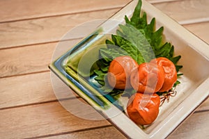 japanese pickled plum with shiso leaf on wooden background