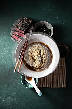 Japanese ramen. Asian soup with noodles ramen, miso, fried tuna steak and seaweed algae