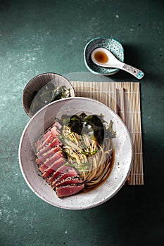 Japanese ramen. Asian soup with noodles ramen, miso, fried tuna steak and seaweed algae