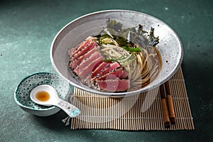 Japanese ramen. Asian soup with noodles ramen, miso, fried tuna steak and seaweed algae