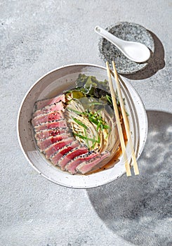 Japanese ramen. Asian soup with noodles ramen, miso, fried tuna steak and seaweed algae on white background