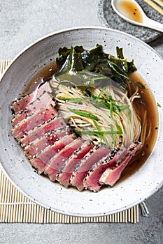 Japanese ramen. Asian soup with noodles ramen, miso, fried tuna steak and seaweed algae on white background