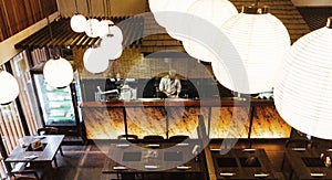 Japanese restaurant counter with chef. Shoot from second floor with lamps in foreground