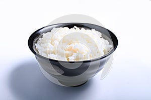 Japanese rice cooked in a black bowl on a white background