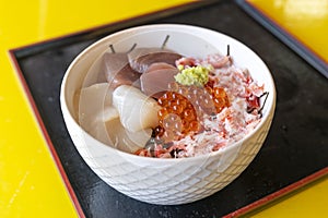 Japanese rice topped with hotate, snow crab, salmon sashimi, and salmon roe