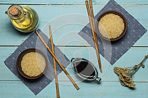 Japanese rice in a wooden bowl. Wooden chopsticks On the table of a bamboo mat. Asian cuisine. View from above.