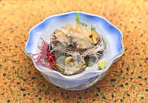Japanese sashimi of fresh Awabi abalone with algae, radish, shiso and wasabi.