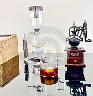 Japanese siphon vacuum coffee maker  black coffee in a clear coffee mug.