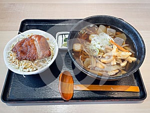 Japanese soba in hot soup with fried pork chop on top of vegetable salad