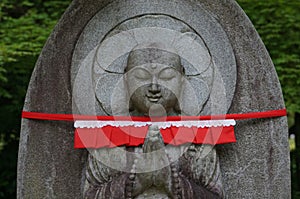 A Japanese stone Buddha praying at Kiyomizu Temple (or Pure Water Temple) in Kyoto, Japan