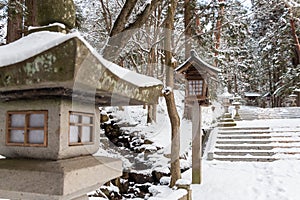 Japanese stone and wooden lantern with snow at Hida-sannogu Hie-Jinja shrine in winter season . At Gifu , Hida Takayama , Japan