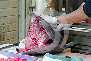 Japanese street food vendor cutting tuna at Tsukiji market in Tokyo