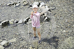 Japanese student girl playing in the river with water gun