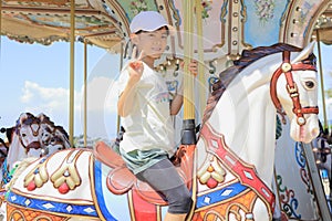 Japanese student girl riding on merry-go-round