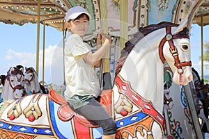 Japanese student girl riding on merry-go-round