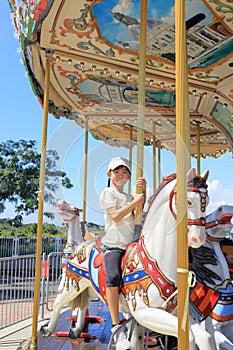 Japanese student girl riding on merry-go-round