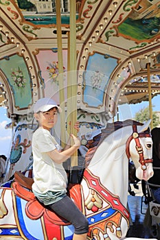 Japanese student girl riding on merry-go-round