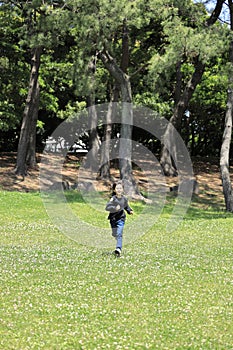 Japanese student girl running on the grass