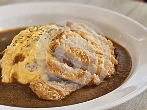 Japanese style deep fried pork with egg omelets curry rice on white plate